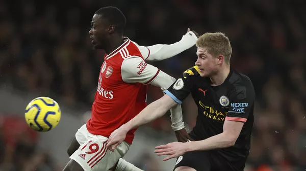 Arsenal's Nicolas Pepe, left, fights for the ball with Manchester City's Kevin De Bruyne during the English Premier League soccer match between Arsenal and Manchester City, at the Emirates Stadium in London, Sunday, Dec. 15, 2019.