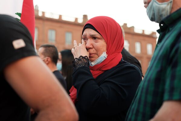یک زن در گردهمایی در تولوز فرانسه برای حمایت از قربانیان انفجار بیروت اشک می‌ریزد - اسپوتنیک افغانستان  