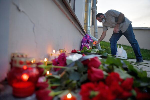 مردی به خاطر یادبود از قربانیان حادثه بیروت در مقابل سفارت لبنان گل می‌گذارد - اسپوتنیک افغانستان  