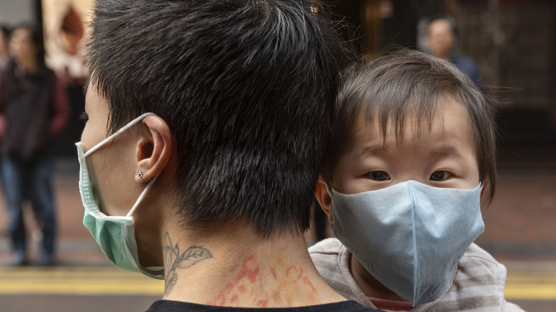 Ребенок в защитной маске на руках отца на одной из улиц в Гонконге - اسپوتنیک افغانستان  , 1920, 10.01.2022