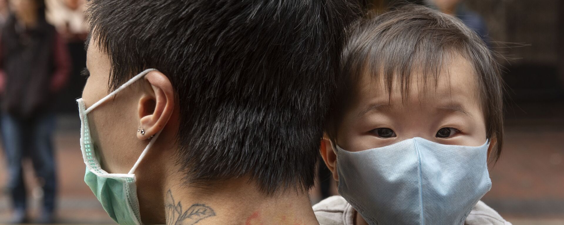 Ребенок в защитной маске на руках отца на одной из улиц в Гонконге - اسپوتنیک افغانستان  , 1920, 10.01.2022