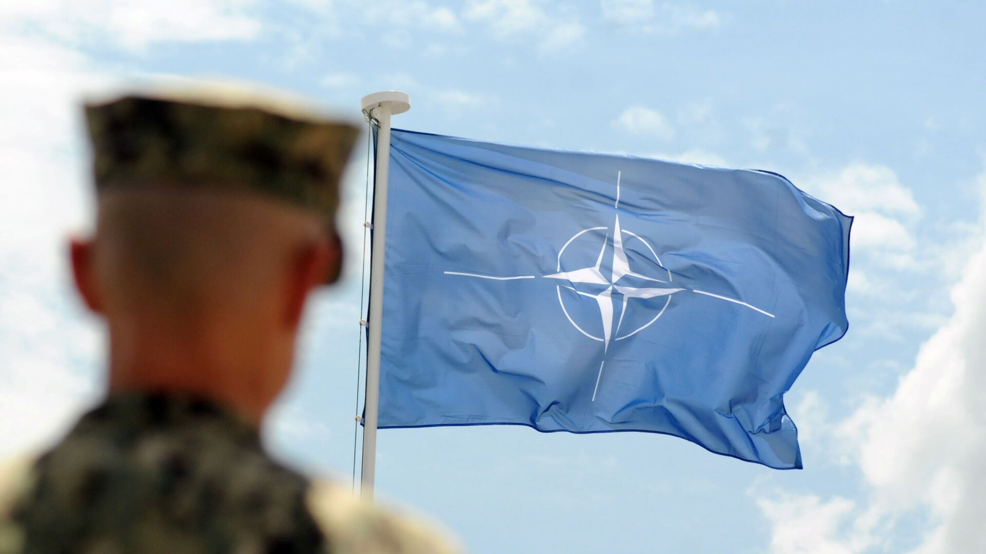 Военнослужащий НАТО на фоне флага НАТО в Косово - اسپوتنیک افغانستان  , 1920, 09.05.2022