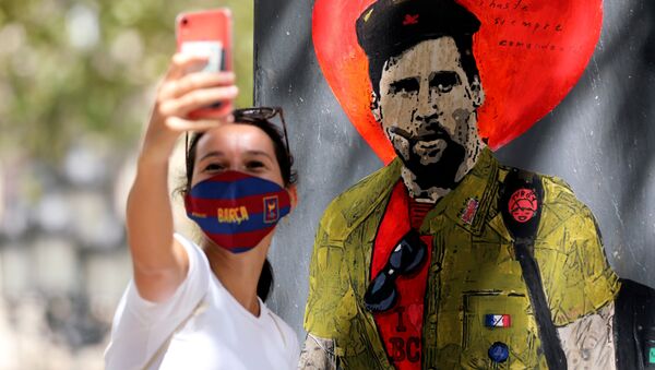 Девушка фотографируется напротив граффити с изображением игрока ФК Барселона Лионель Месси в Испании  - اسپوتنیک افغانستان  