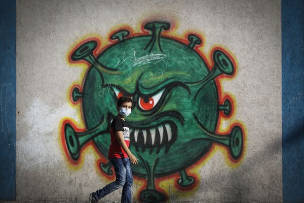 پسری در کنار گرافیتی ویروس کرونا در غزه فلسطین - اسپوتنیک افغانستان  