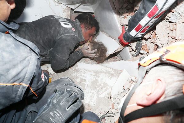 نجات یک کودک از زیر ساختمانیکه در زلزله شهر اذمیر ترکیه فرو رفته است. - اسپوتنیک افغانستان  