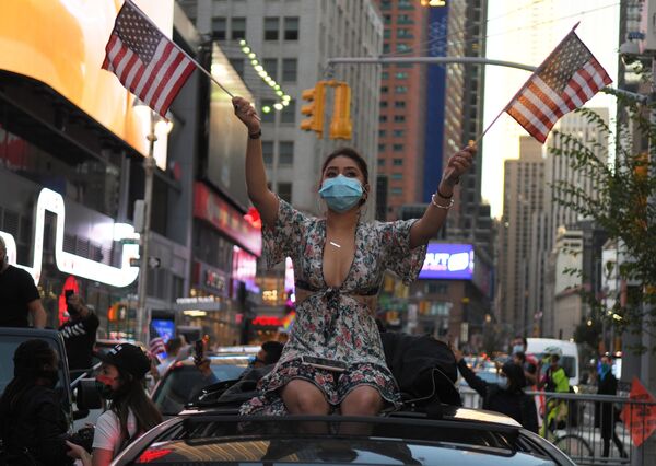 دختری در یکی از خیابان های نیویورک در حال شادی برای پیروزی جو بایدن در انتخابات ریاست جمهوری - اسپوتنیک افغانستان  