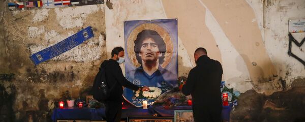 Люди зажигают свечи в честь легенды футбола Диего Марадоны в районе Quartieri Spagnoli в Неаполе - اسپوتنیک افغانستان  