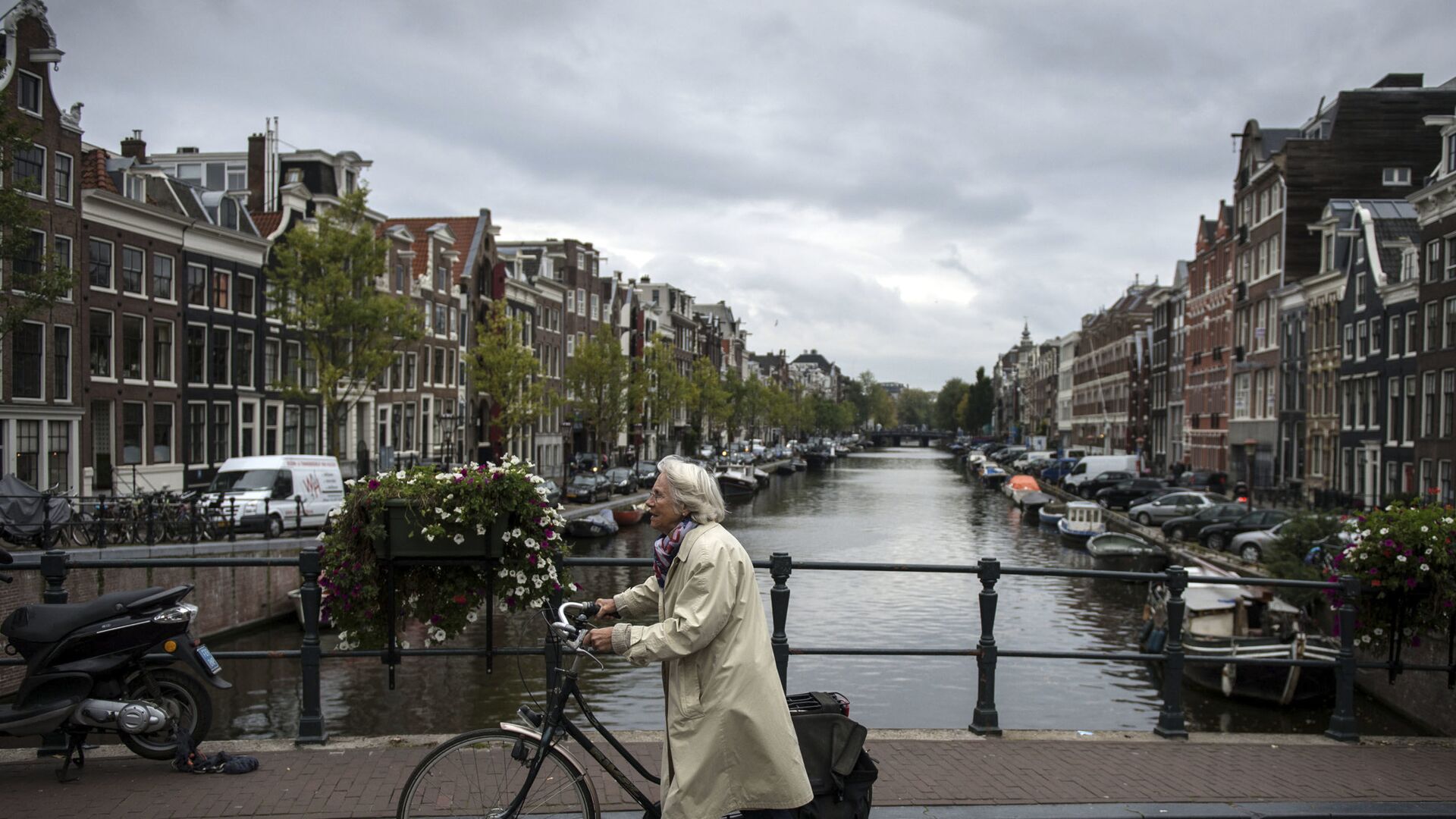 Пожилая женщина с велосипедом на мосту в центре Амстердама - اسپوتنیک افغانستان  , 1920, 04.05.2023