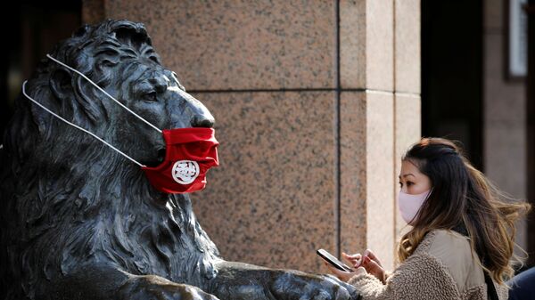 Женщина в защитной маске перед статуей в Токио  - اسپوتنیک افغانستان  