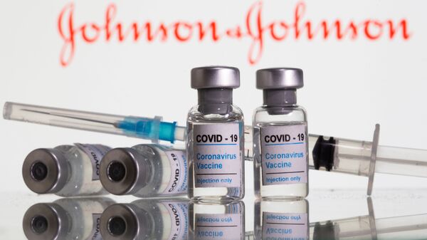 Vials labelled COVID-19 Coronavirus Vaccine and sryinge are seen in front of displayed Johnson&Johnson logo in this illustration taken, February 9, 2021 - اسپوتنیک افغانستان  