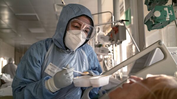 Медсестра кормит пациента в отделении реанимации и интенсивной терапии в больнице в Москве - اسپوتنیک افغانستان  