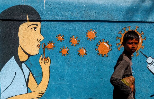 عبور پسری از پیش روی دیوار نقاشی شده در بمبئی هند. - اسپوتنیک افغانستان  
