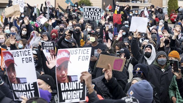 People gather before curfew holding pictures of Daunte Wright along with Black Lives Matter signs to protest his death by a police officer in Brooklyn Center, Minnesota on April 12, 2021.  - اسپوتنیک افغانستان  