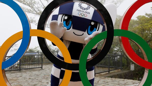 Талисман Летней Олимпиады в Токио Miraitowa позирует сзади Олимпийских колец после мероприятия по случаю 100 дней до Олийписких игр в Токио  - اسپوتنیک افغانستان  