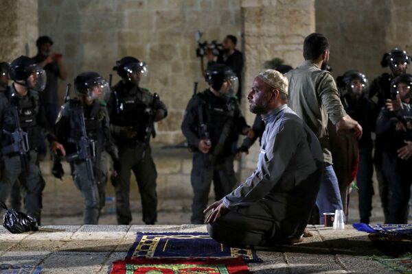 ادای نماز یک فلسطینی هنگام درگیری ها با سربازان اسرائیلی. - اسپوتنیک افغانستان  