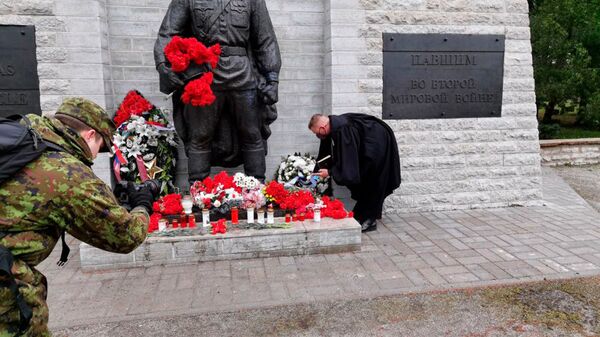 تقدیم تاج گل توسط روحانی نیروهای دفاعی استونی به یادبود جانباختگان در جنگ جهانی دوم در قبرستان نظامی تالین - اسپوتنیک افغانستان  