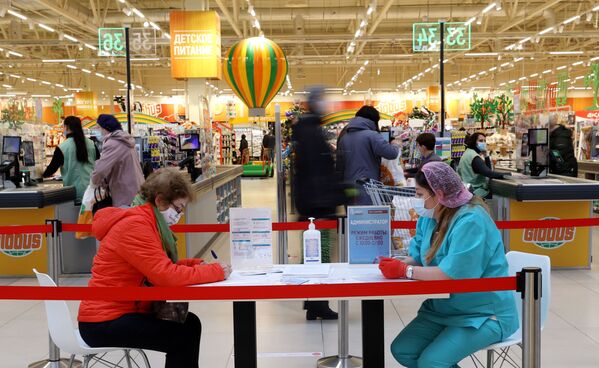 خانمی درحال تکمیل اسناد برای گرفتن واکسین روسی، در یکی از مرکزهای خرید در شهر مسکو. - اسپوتنیک افغانستان  