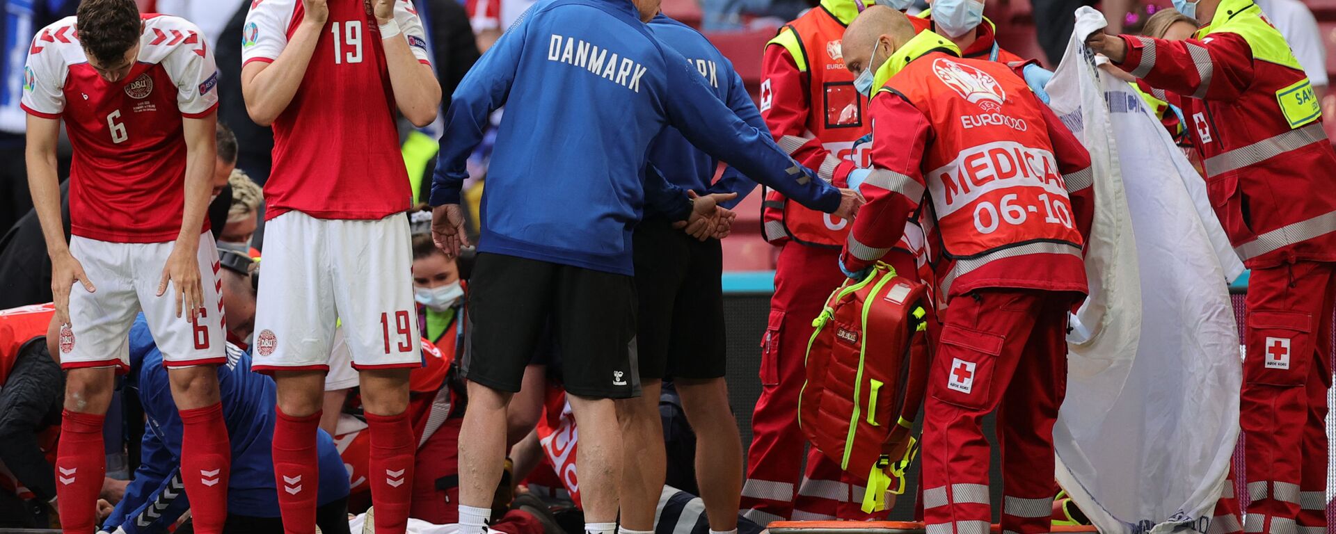 Denmark's players react as paramedics attend to Denmark's midfielder Christian Eriksen after he collapsed on the pitch during the UEFA EURO 2020 Group B football match between Denmark and Finland at the Parken Stadium in Copenhagen on June 12, 2021. - اسپوتنیک افغانستان  , 1920, 14.06.2021