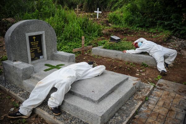 کارگران با لباس محافظ پس از دفن یک قربانیان بیماری ویروس کرونا (COVID-19) در باندونگ ، اندونزی - اسپوتنیک افغانستان  