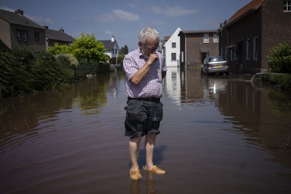 مردی در اطراف خانه‌اش که غرق در آب است در هالند. - اسپوتنیک افغانستان  