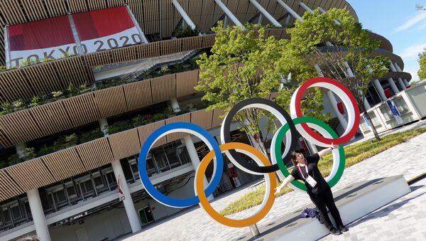 A woman poses in front of the National Stadium, the main stadium of Tokyo 2020 Olympics and Paralympics in Tokyo, Japan July 23, 2021. - اسپوتنیک افغانستان  