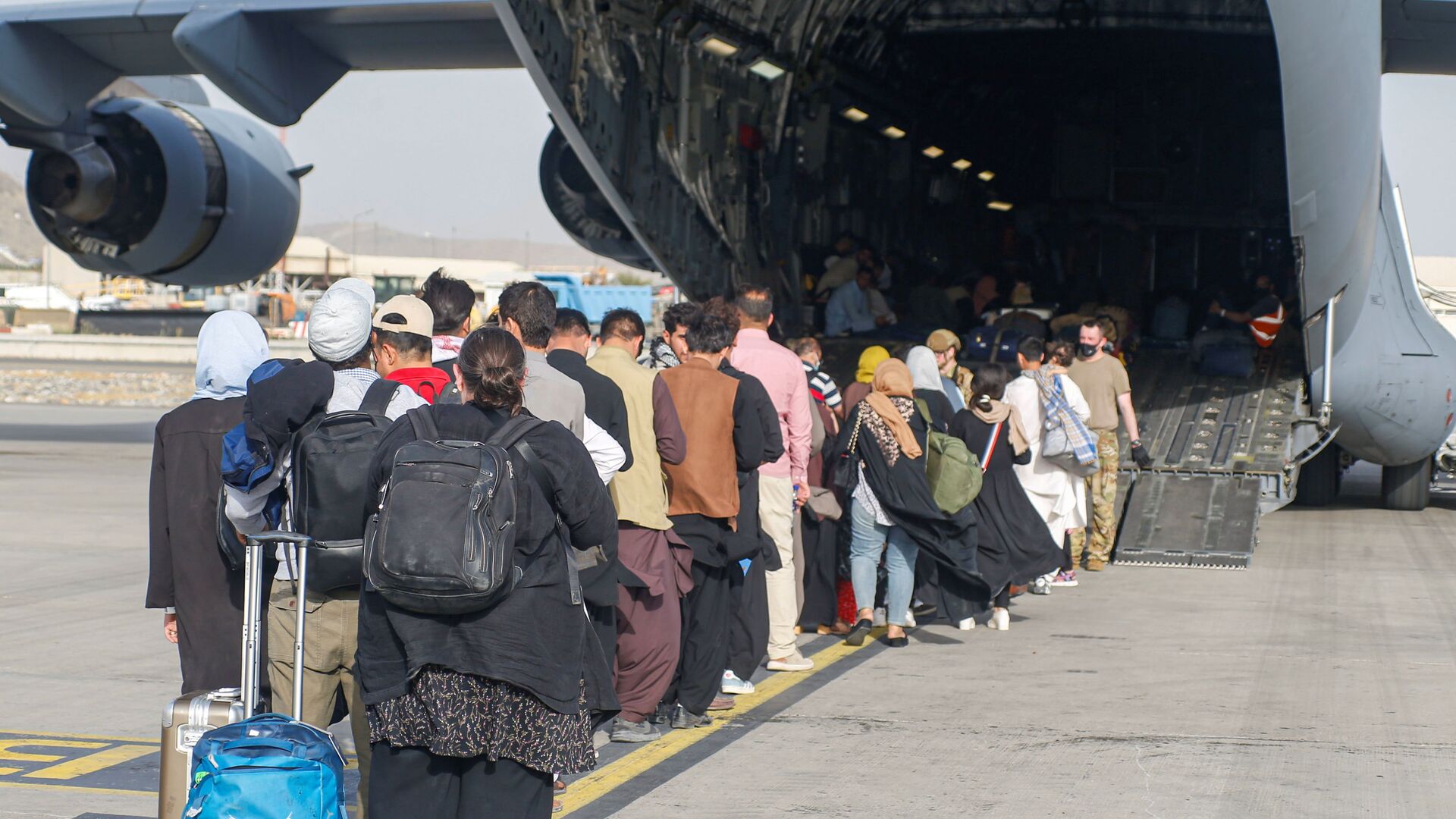 Афганские беженцы во время посадки на самолет C-17 Globemaster III ВВС США в международном аэропорту имени Хамида Карзая в Кабуле - اسپوتنیک افغانستان  , 1920, 22.01.2022