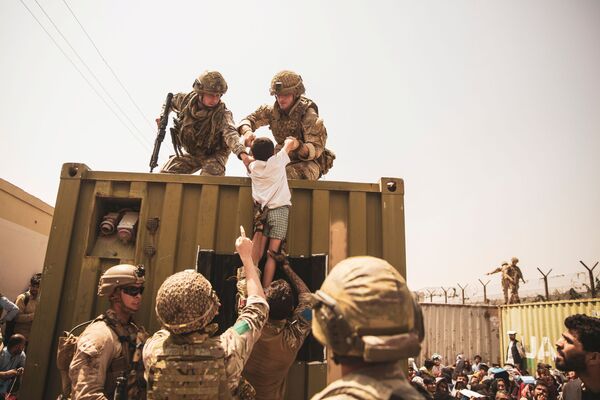 سربازان بریتانیایی، ترکی و آمریکایی با کودکان در هنگام تخلیه در فرودگاه کابل - اسپوتنیک افغانستان  