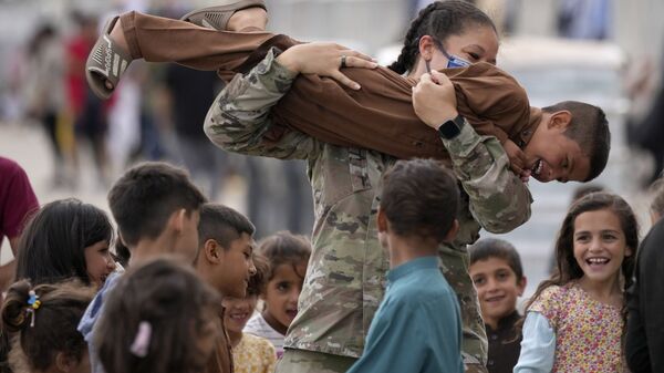 Американский солдат играет с недавно эвакуированными афганскими детьми на авиабазе Рамштайн, Германия - اسپوتنیک افغانستان  