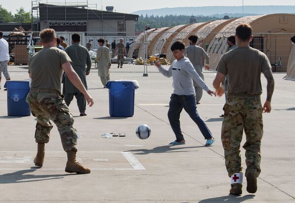 نظامیان آمریکایی هنگام بازی فوتبال با کودکان افغان در پایگاه نظامی رامشتین در آلمان - اسپوتنیک افغانستان  