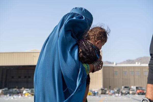 زن افغان با کودک اش هنگام تخلیه در کابل - اسپوتنیک افغانستان  