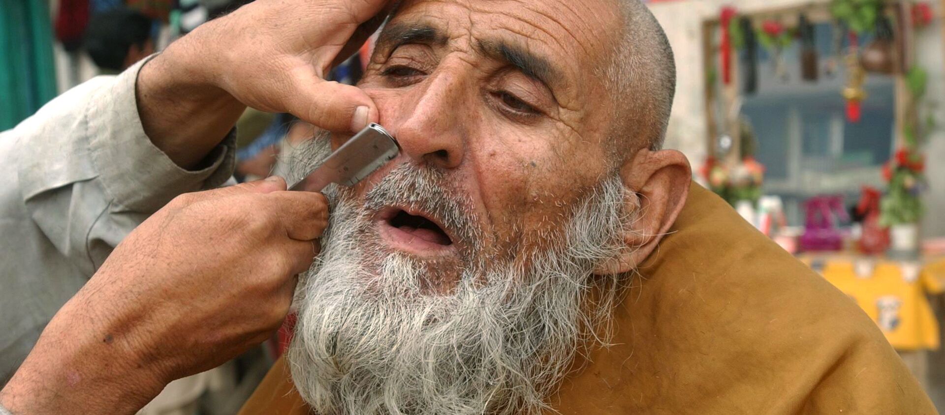 Уличный парикмахер бреет клиента в Джелалабаде, 2006 год - اسپوتنیک افغانستان  , 1920, 01.11.2021