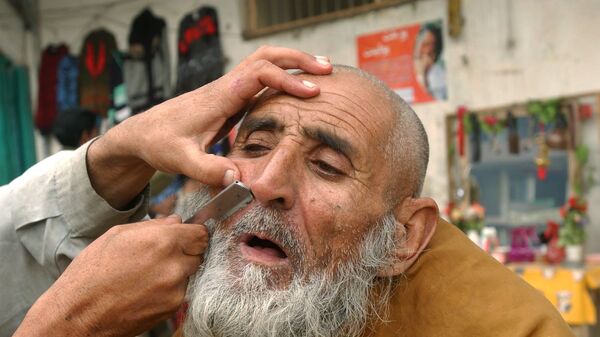 Уличный парикмахер бреет клиента в Джелалабаде, 2006 год - اسپوتنیک افغانستان  
