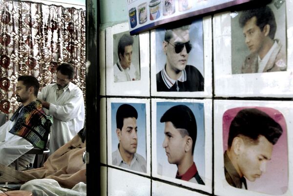  آرایشگاهی در کابل سال 2002، عکس هایی روی دیوار آویزان که سبک های مختلف موها و صورت بدون ریش را نشان می دهد - اسپوتنیک افغانستان  