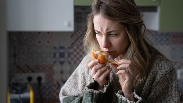 Женщина пытается почувствовать запах мандарина - اسپوتنیک افغانستان  