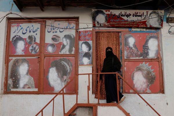 زن چادری پوش افغان نزدیک آرایشگاهی در کابل. - اسپوتنیک افغانستان  