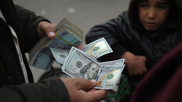 Мужчина держит афганские банкноты и доллары США на валютном рынке Сараи Шахзада в Кабуле - اسپوتنیک افغانستان  