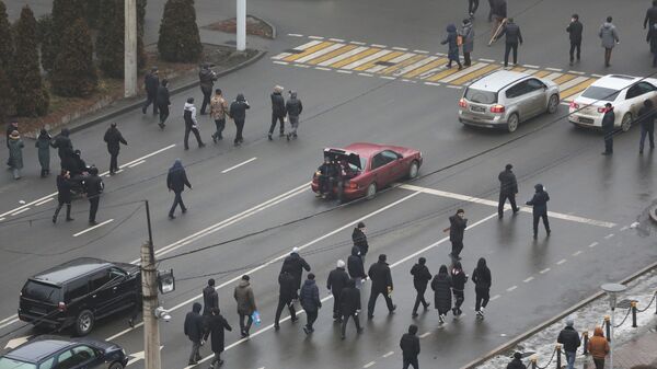 Демонстранты идут по улице во время акции протеста, вызванной повышением цен на топливо в Алматы - اسپوتنیک افغانستان  