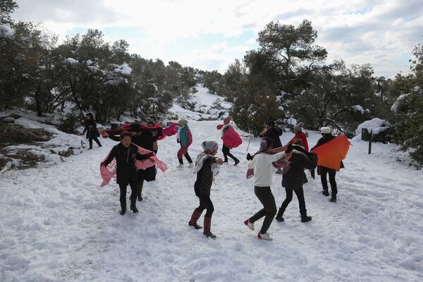 شهروندان چینایی ساکن یونان هنگام بازی با برف در یونان.  - اسپوتنیک افغانستان  