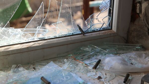 Разбитое окно и гильзы на подоконнике в жилом доме в Киевском районе Донецка - اسپوتنیک افغانستان  