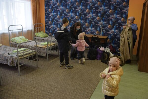 ساکنان دونباس در بس هایی که پناهجویان با آنها به اقامتگاه های موقت منتقل می شوند. قرار است این افراد در کمپ های کودکان در مراکز اسکان موقت مستقرشوند. - اسپوتنیک افغانستان  