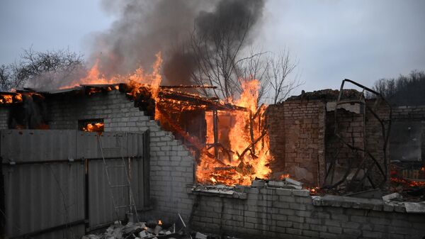 Пожар в жилом доме в Киевском районе Донецка, разрушенном в результате обстрела - اسپوتنیک افغانستان  