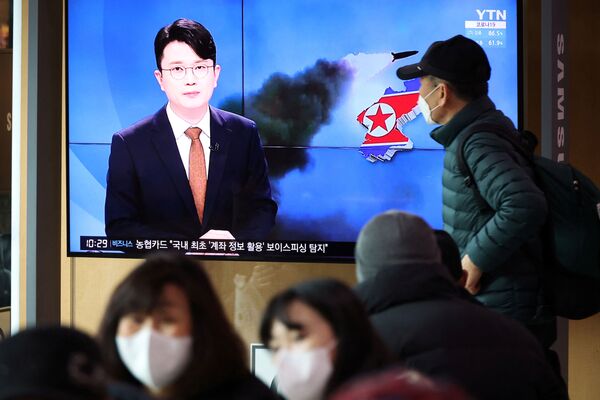 مردم در سئول، 5 مارچ سال 2022، در حال تماشای تلویزیون هستند که گزارشی در مورد شلیک راکت بالستیک کوریای شمالی از سواحل شرقی این کشور پخش می‌کند. - اسپوتنیک افغانستان  