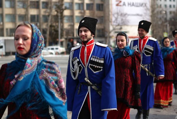 مردم در مراسم رسمی برافراشتن پرچم ملی روسیه به افتخار روز اتحاد کریمه با روسیه در میدان اصلی شهر کراسنودار. - اسپوتنیک افغانستان  