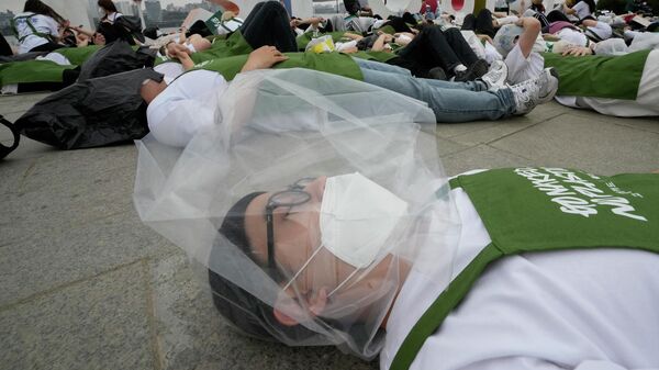 Экологический активист с пластиковым пакетом во время кампании по празднованию Дня Земли против изменения климата в Сеуле, Южная Корея - اسپوتنیک افغانستان  
