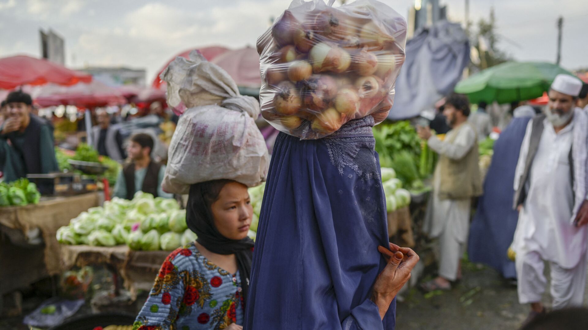 Женщина в парандже несет на голове мешок с луком на рынке в Кабуле - اسپوتنیک افغانستان  , 1920, 18.06.2022