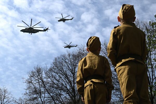 هلیکوپتر ترابری چند منظوره سنگین Mi-26 و هلیکوپتر تهاجمی Mi-24 در تمرین لباس رژه نظامی در هفتاد و هفتمین سالگرد پیروزی در مسکو. - اسپوتنیک افغانستان  