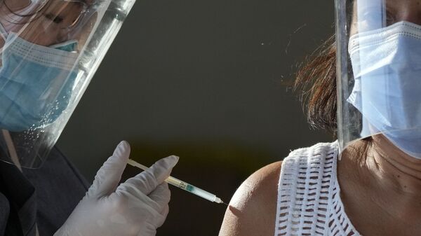 In this Tuesday, June 22, 2021 file photo, a health worker inoculates a woman with China's Sinovac COVID-19 vaccine at a temporary vaccination center in Manila, Philippines - اسپوتنیک افغانستان  