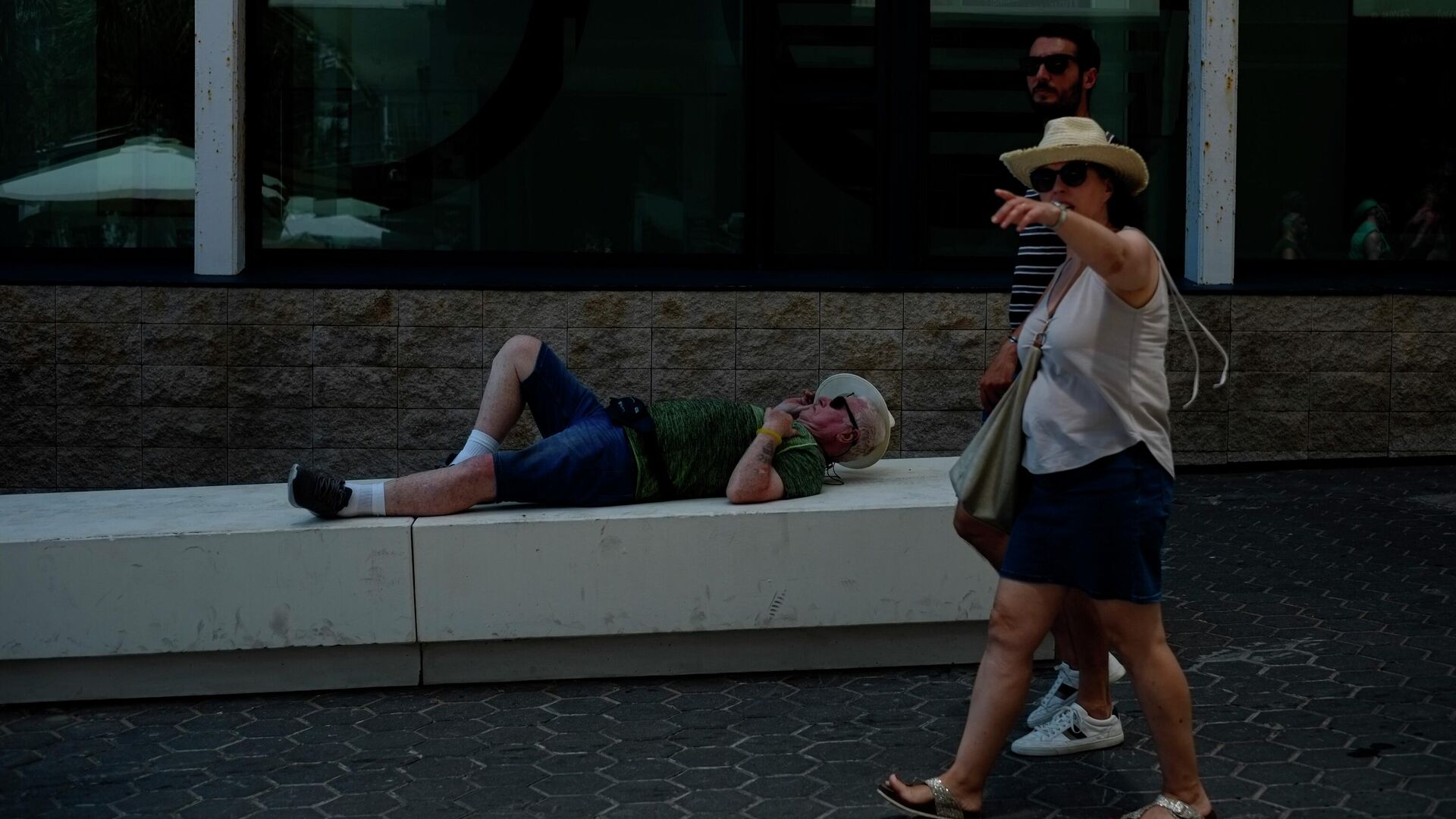 Турист отдыхает, пока люди гуляют солнечным весенним днем, в Бенидорме, Испании  - اسپوتنیک افغانستان  , 1920, 16.07.2022