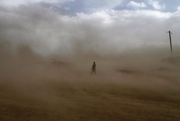 تصویری از افغانستان مردی را در حال گرفتار شدن در طوفان گرد و خاک در کابل نشان می‎دهد. - اسپوتنیک افغانستان  
