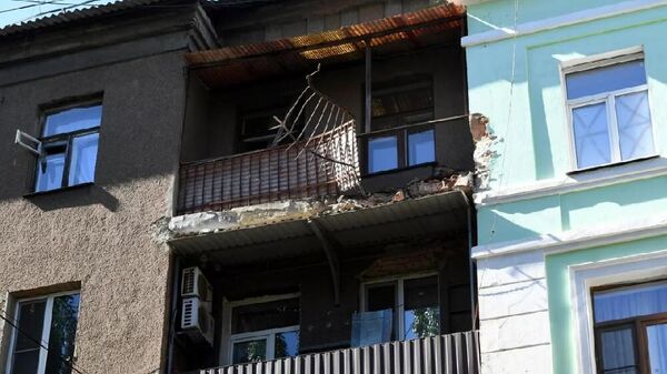 Сотрудники НМ ДНР осматривают фасад жилого дома, поврежденного в результате обстрела ВСУ одного из районов Донецка. - اسپوتنیک افغانستان  